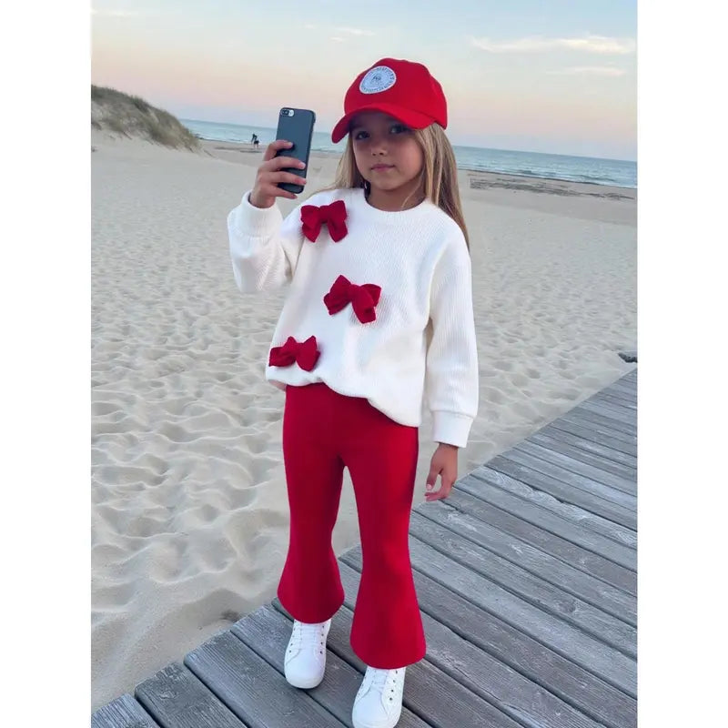 This Charming Chic Kids White Ribbed Sweater with Unique 3D Red Bows & Eye-catching Red Flared Trousers Outfit is Picture-Perfect Ideal for Holiday Photo Shoots Special Occasions or a Stylish Fall/Winter Wardrobe Comfy & Cute Toddler Girl FashionStatement