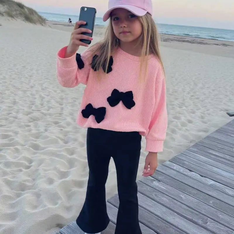 This Charming Chic Kids White Ribbed Sweater with Unique 3D Red Bows & Eye-catching Red Flared Trousers Outfit is Picture-Perfect Ideal for Holiday Photo Shoots Special Occasions or a Stylish Fall/Winter Wardrobe Comfy & Cute Toddler Girl FashionStatement