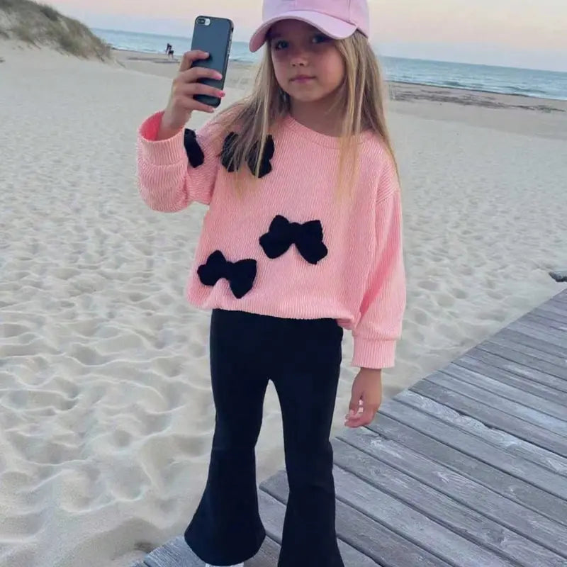 This Charming Chic Kids White Ribbed Sweater with Unique 3D Red Bows & Eye-catching Red Flared Trousers Outfit is Picture-Perfect Ideal for Holiday Photo Shoots Special Occasions or a Stylish Fall/Winter Wardrobe Comfy & Cute Toddler Girl FashionStatement