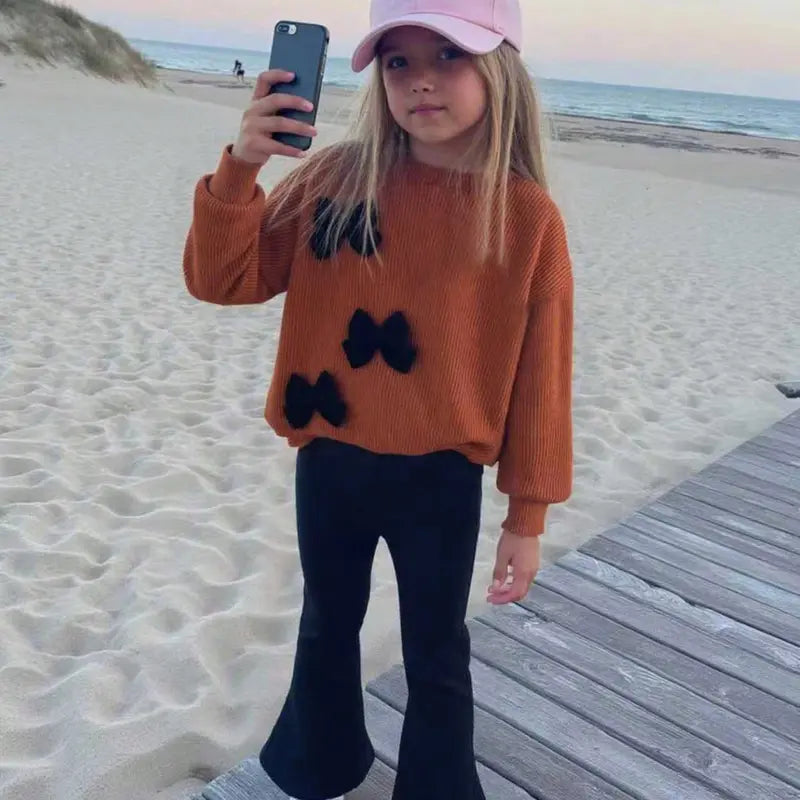 This Charming Chic Kids White Ribbed Sweater with Unique 3D Red Bows & Eye-catching Red Flared Trousers Outfit is Picture-Perfect Ideal for Holiday Photo Shoots Special Occasions or a Stylish Fall/Winter Wardrobe Comfy & Cute Toddler Girl FashionStatement